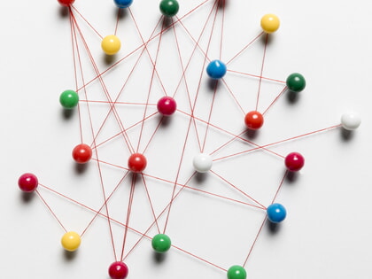 Pinnadeln mit Faden zu einem Netz verbunden